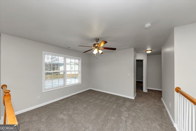 empty room with dark colored carpet and ceiling fan