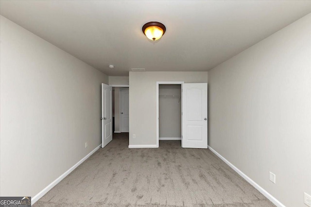 unfurnished bedroom featuring light colored carpet and a closet