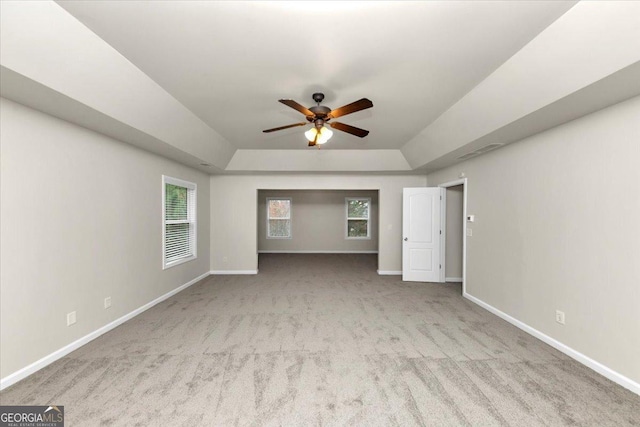 interior space with ceiling fan and a raised ceiling