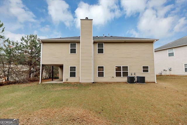 rear view of house with a patio area, cooling unit, and a yard