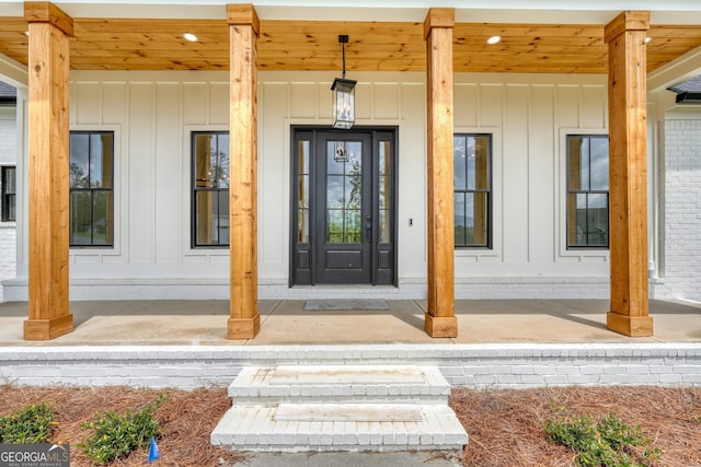 doorway to property featuring board and batten siding and covered porch
