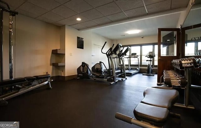 workout area with a paneled ceiling and a healthy amount of sunlight