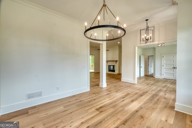 unfurnished dining area with visible vents, ornamental molding, baseboards, and a notable chandelier