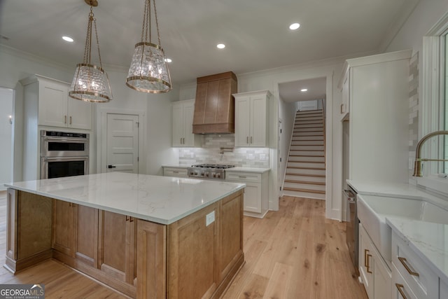 kitchen with crown molding, tasteful backsplash, custom range hood, a sink, and appliances with stainless steel finishes