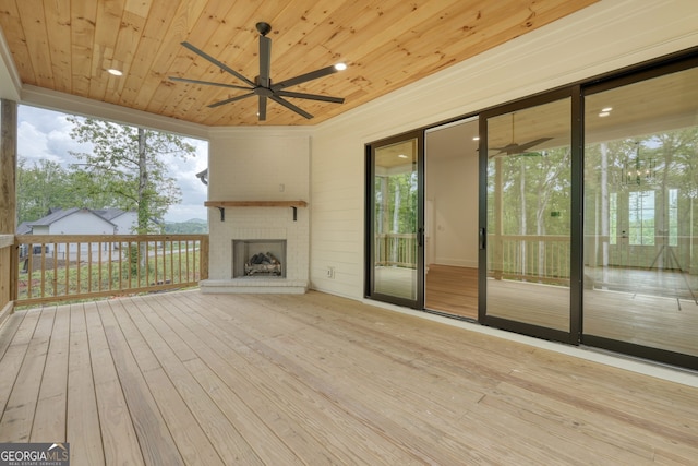 wooden deck featuring ceiling fan and an outdoor brick fireplace