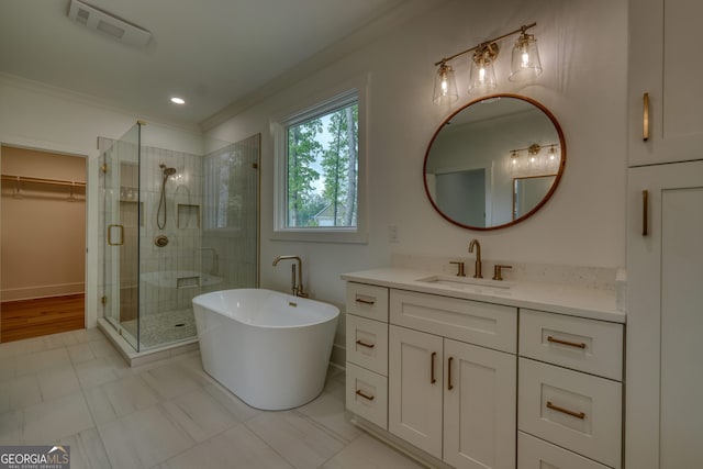 full bathroom with a walk in closet, vanity, a shower stall, visible vents, and ornamental molding