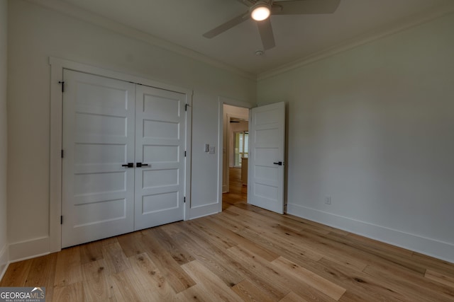 unfurnished bedroom featuring baseboards, ornamental molding, and light wood-type flooring