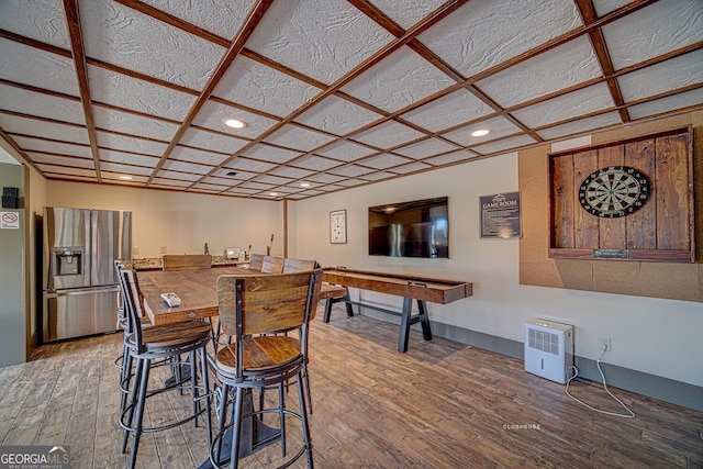 interior space with recessed lighting, stainless steel fridge with ice dispenser, indoor wet bar, and hardwood / wood-style flooring