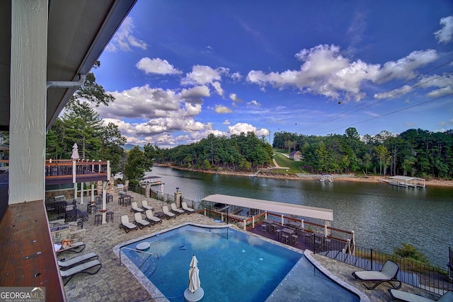 community pool featuring a water view, a patio, and a boat dock