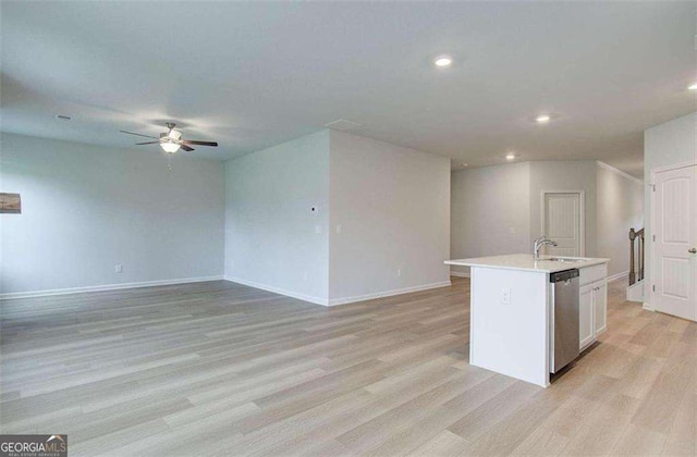 kitchen featuring light hardwood / wood-style floors, dishwasher, a kitchen island with sink, white cabinets, and sink