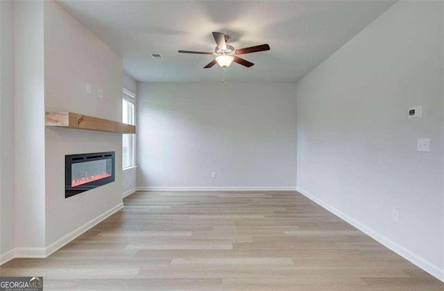 unfurnished living room with ceiling fan and light hardwood / wood-style floors