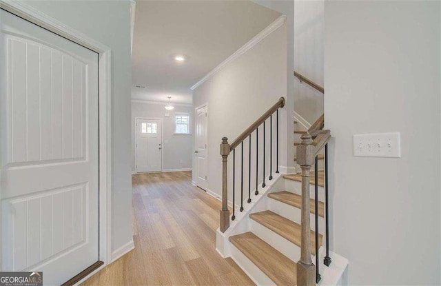 staircase featuring hardwood / wood-style flooring and ornamental molding