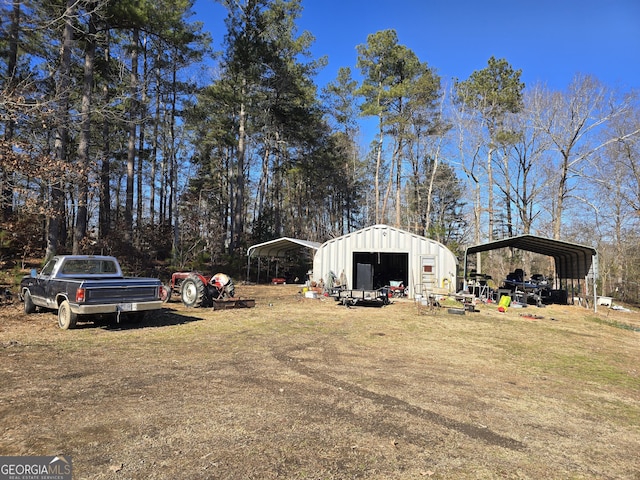 view of yard featuring a garage, a carport, and an outdoor structure