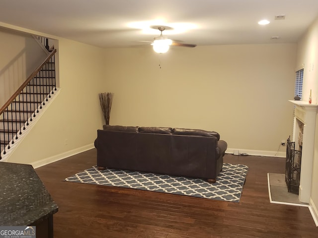 living room with ceiling fan and dark hardwood / wood-style flooring