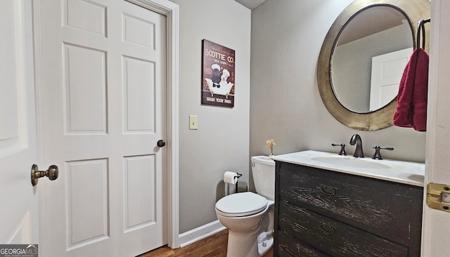 bathroom with hardwood / wood-style flooring, vanity, and toilet