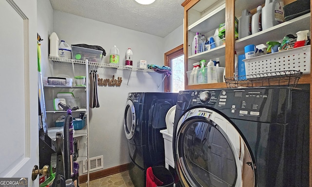 laundry area featuring a textured ceiling and washer and clothes dryer