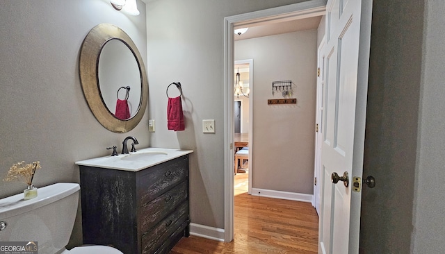 bathroom with vanity, toilet, and hardwood / wood-style floors