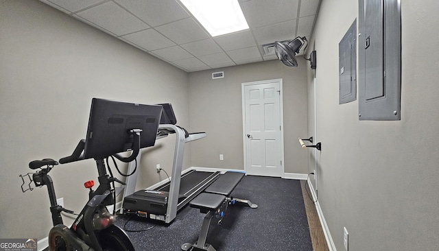 exercise room with a paneled ceiling and electric panel