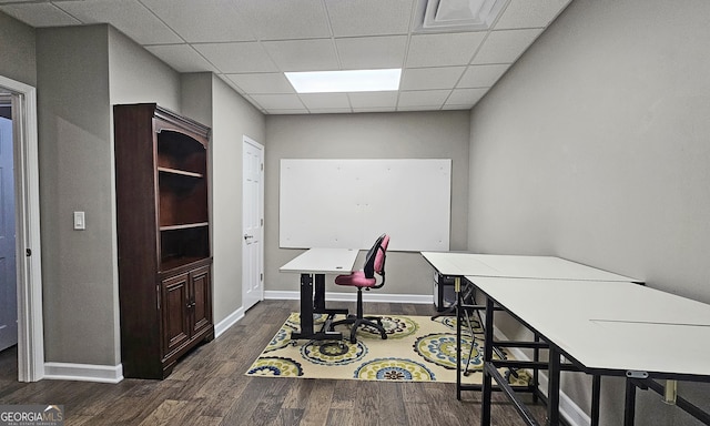 home office with a paneled ceiling and dark hardwood / wood-style flooring