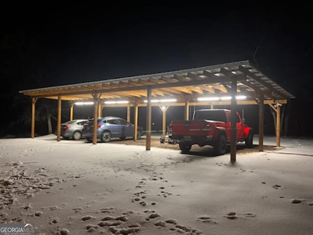 snow covered parking featuring a carport