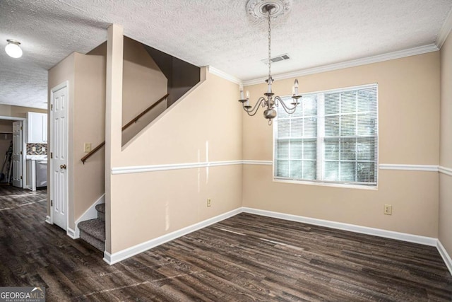 unfurnished dining area with crown molding, dark hardwood / wood-style flooring, a chandelier, and a textured ceiling