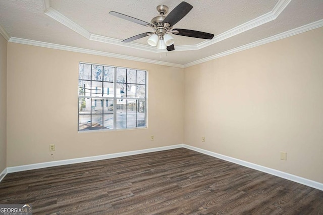 empty room featuring ceiling fan, a tray ceiling, ornamental molding, a textured ceiling, and dark hardwood / wood-style flooring