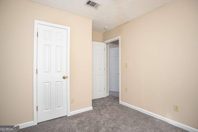 unfurnished bedroom featuring light colored carpet and a textured ceiling