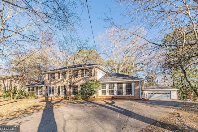 view of front of house featuring a garage and an outbuilding