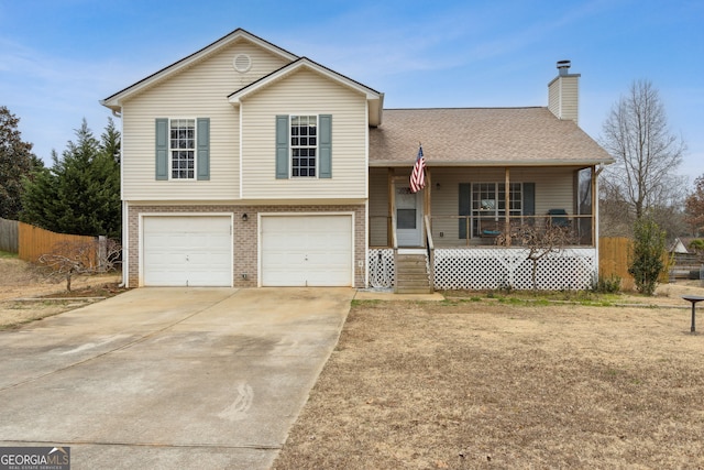 split level home with a garage, a front lawn, and covered porch