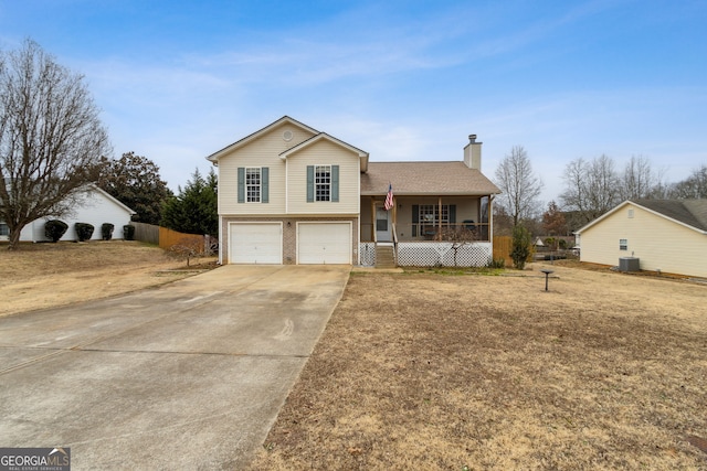 split level home with a garage, a front lawn, central AC, and covered porch