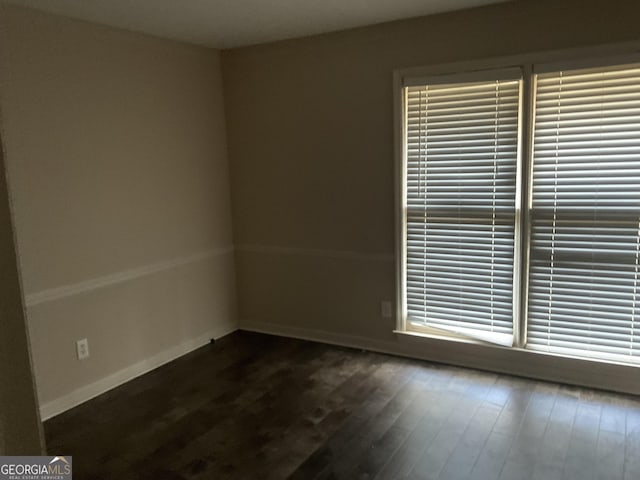 unfurnished room featuring dark wood-type flooring