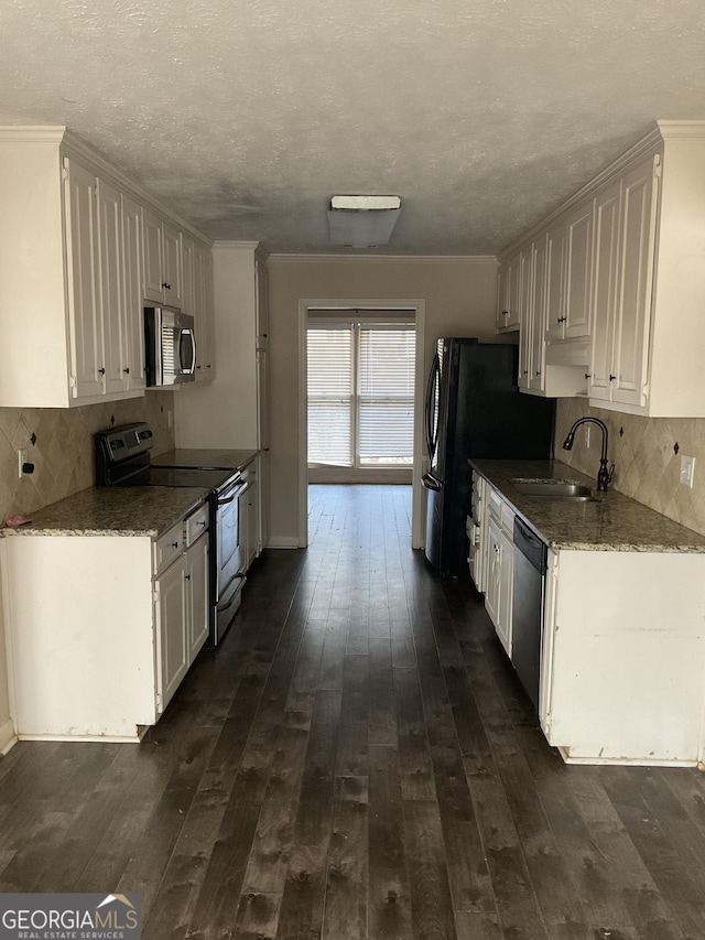 kitchen with appliances with stainless steel finishes, dark hardwood / wood-style floors, sink, and white cabinets