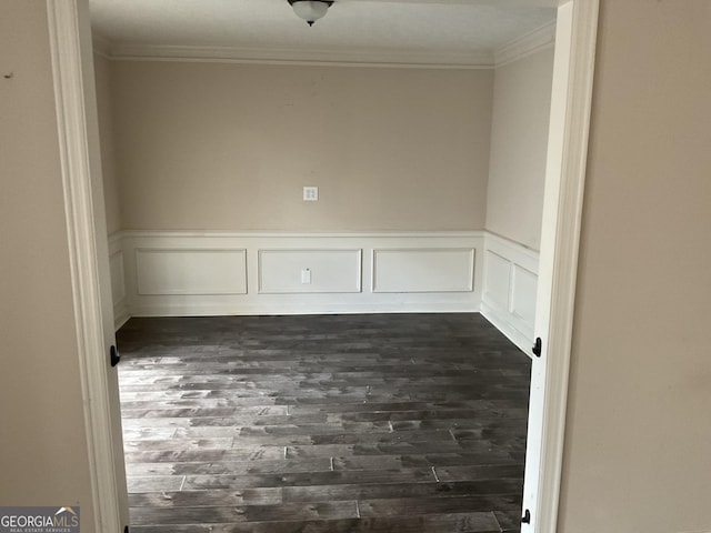 spare room featuring ornamental molding and dark hardwood / wood-style floors