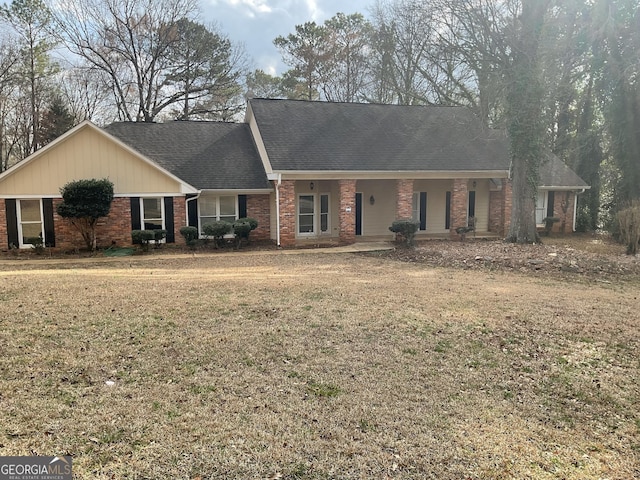 ranch-style home featuring covered porch and a front lawn