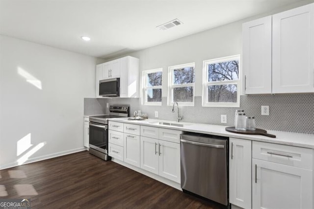 kitchen featuring stainless steel appliances, sink, white cabinets, and dark hardwood / wood-style floors