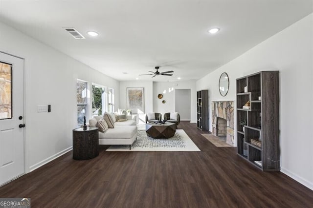 living room with dark wood-type flooring and ceiling fan