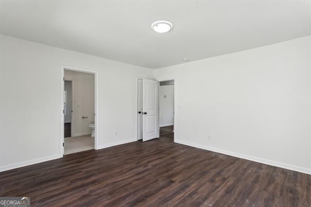 unfurnished room with dark hardwood / wood-style flooring