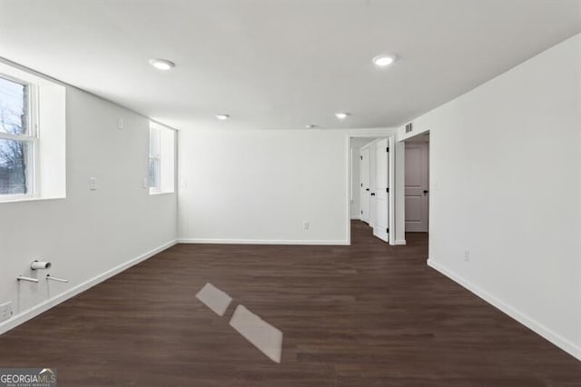 unfurnished room featuring dark wood-type flooring and plenty of natural light