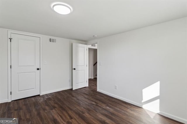 unfurnished bedroom with dark wood-type flooring