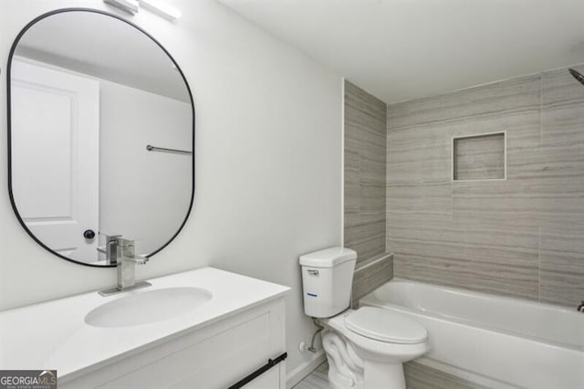 full bathroom with tiled shower / bath, vanity, and toilet