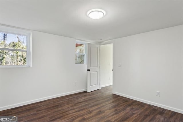 empty room with dark hardwood / wood-style flooring