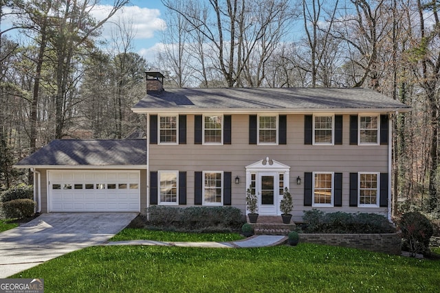 colonial house featuring a garage, a chimney, a front lawn, and concrete driveway