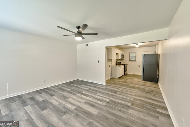 unfurnished living room with ceiling fan and light hardwood / wood-style flooring