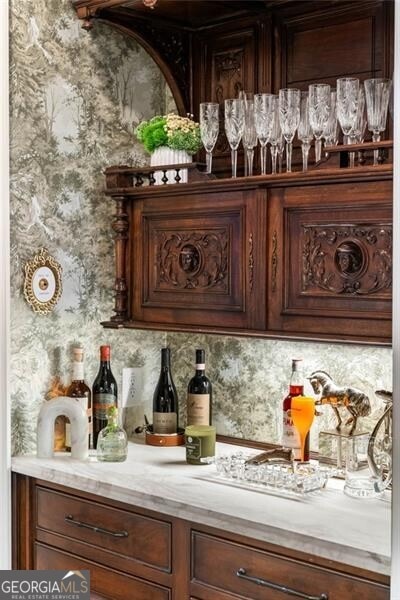 bar with dark brown cabinetry and decorative backsplash