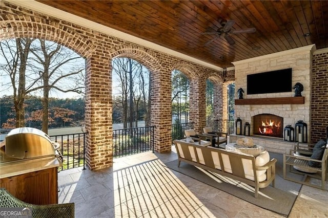 view of patio / terrace featuring an outdoor living space with a fireplace and ceiling fan