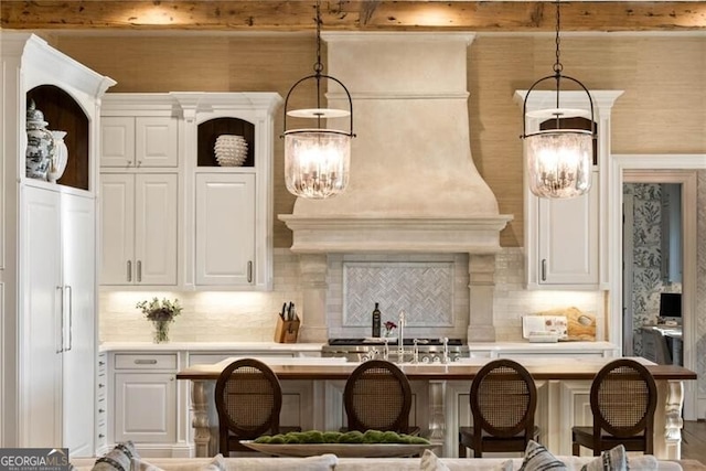 kitchen with tasteful backsplash, decorative light fixtures, a chandelier, and white cabinets