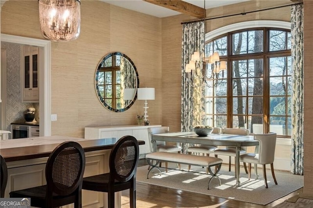 dining area with beamed ceiling, wood-type flooring, and a notable chandelier