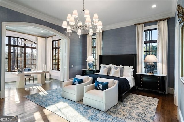 bedroom with ornamental molding, hardwood / wood-style floors, and a chandelier