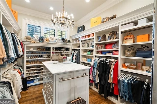 spacious closet with dark hardwood / wood-style flooring and a notable chandelier