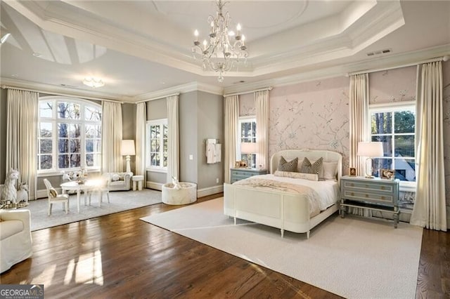 bedroom with crown molding, a tray ceiling, and multiple windows